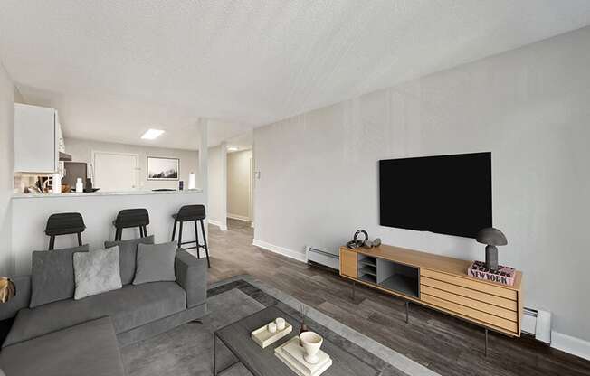 Model Living Room with Wood-Style Flooring and View of Kitchen at Middlesex Crossing Apartments in Billerica, MA.