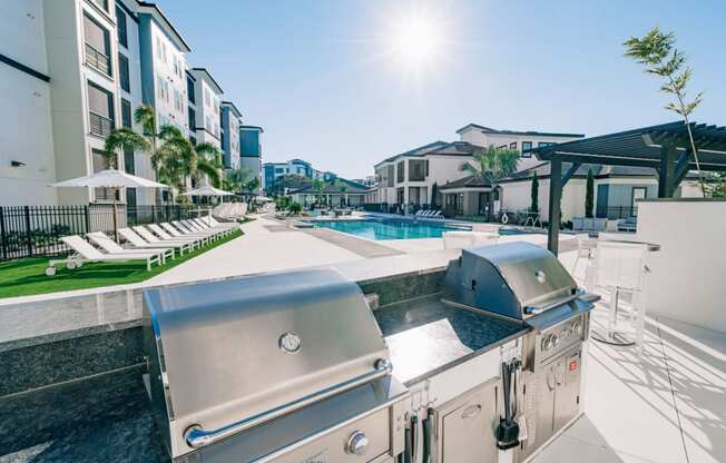 Outdoor BBQ and picnic area with grilling stations at The Pointe on Westshore apartment rentals in Tampa, FL
