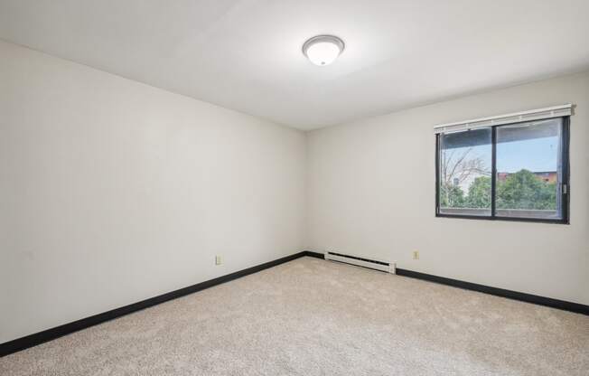 a white room with a window and a carpet