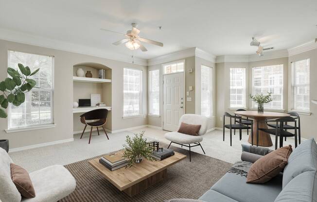 View of Cottonwood Ridgeview Living Room Showing Built In Office Desk, Dining Table and Chairs, Living Room Area Showing Couch, Two Chairs and Wooden Coffee Table and Ceiling Fans