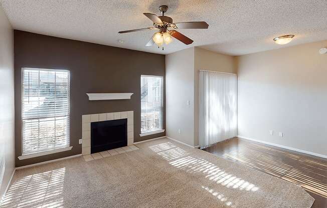 a living room with a fireplace and a ceiling fan