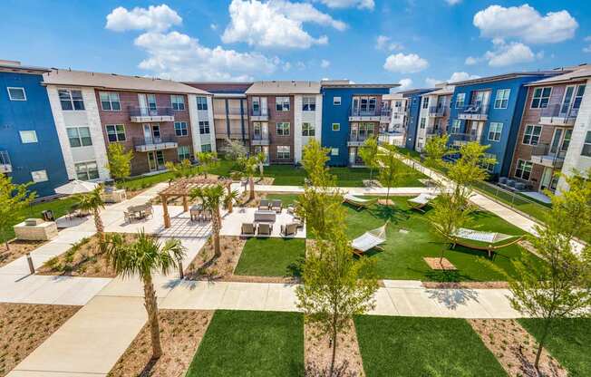 A sunny day at a residential complex with palm trees and a playground.