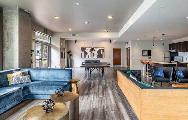 A modern living room with a blue couch and a wooden floor.