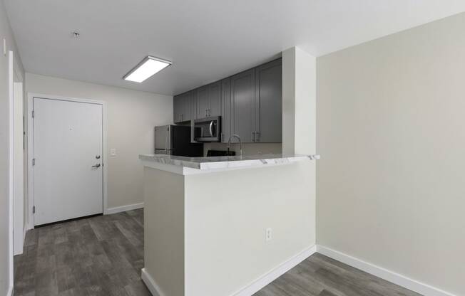 Kitchen View with a Counter Top Breakfast Bar at Excalibur Apartment Homes, WA 98004