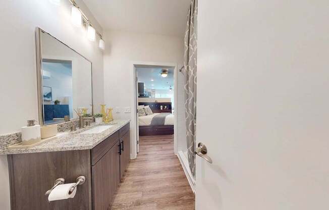 A bathroom with a marble countertop and a large mirror.