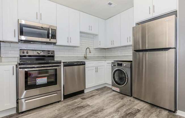 a kitchen with stainless steel appliances and white cabinets