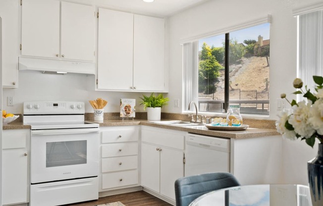 a white kitchen with white appliances and white cabinets