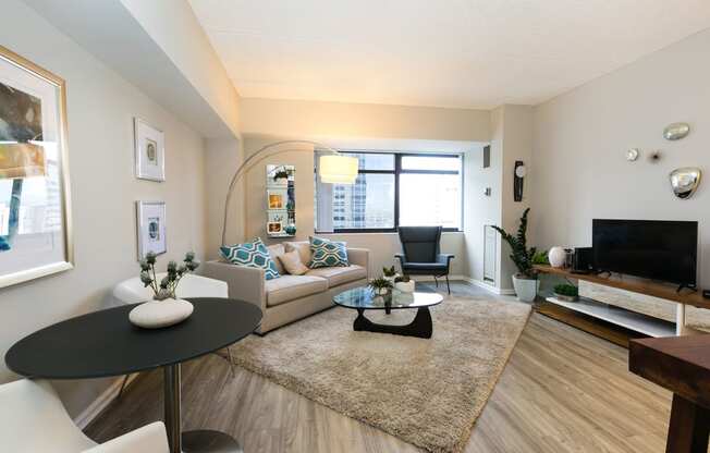 a living room with a couch and a table and a television at Apartments at Denver Place, Colorado, 80202
