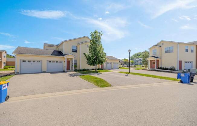 A residential area with houses and a tree in the foreground.