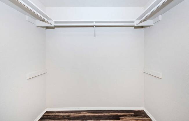 an empty room with white walls and a wood floor