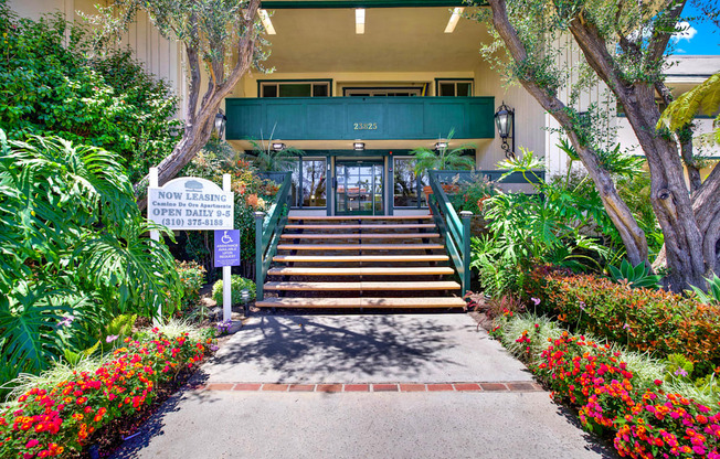 the steps up to the front of a building with plants and flowers at Camino de Oro Apartments, Torrance, CA, 90505
