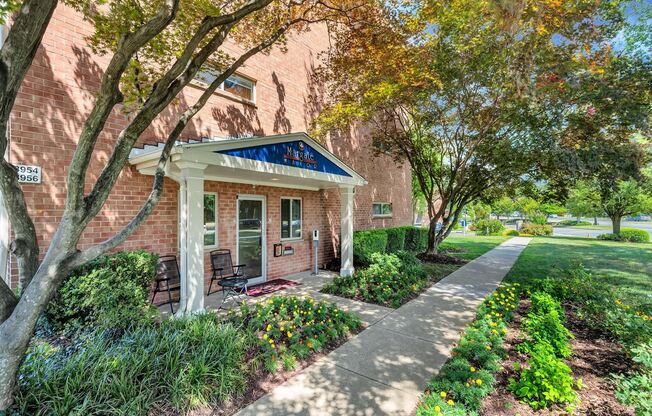 a brick building with a blue awning and a sidewalk in front of it