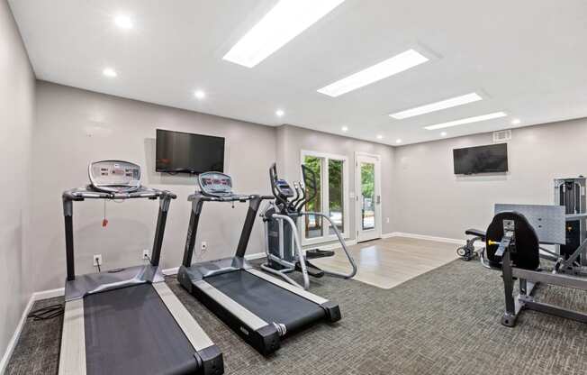 Newly remodeled fitness center and gym showing treadmills and yoga or HIIT floor