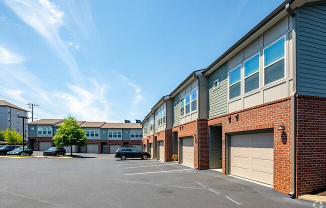 a parking lot with brick buildings and garages