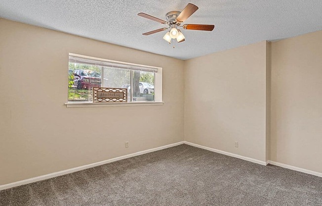 a living room with a ceiling fan and a window