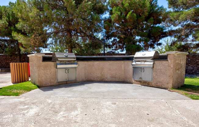 two barbecue grills on the side of a driveway