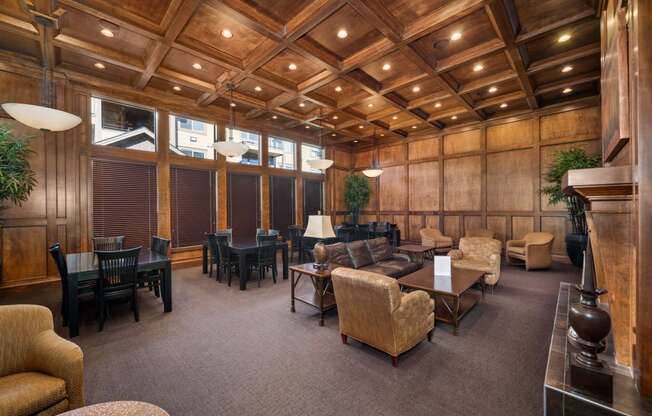 a living room with couches chairs and tables and a wooden ceiling