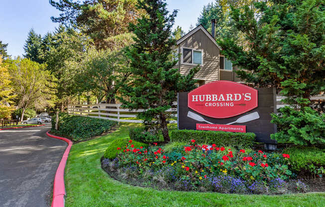 A sign for Hubbard's Crossing in front of a house.