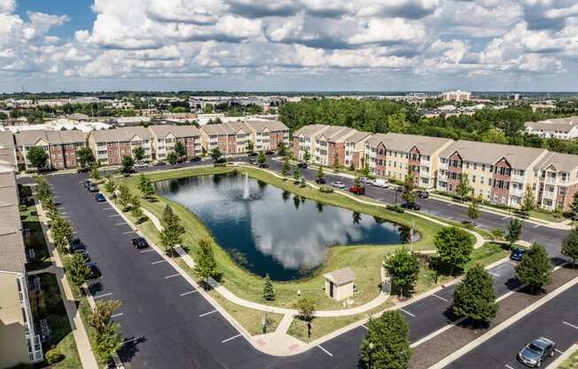 an aerial view of a pond in the middle of an apartment complex