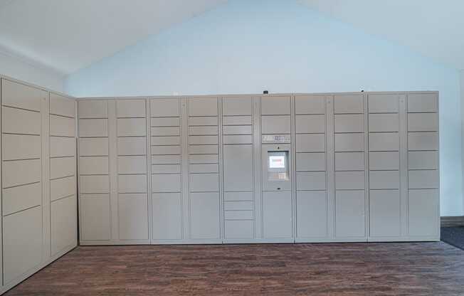 A room with a wall of lockers and a door on the right.