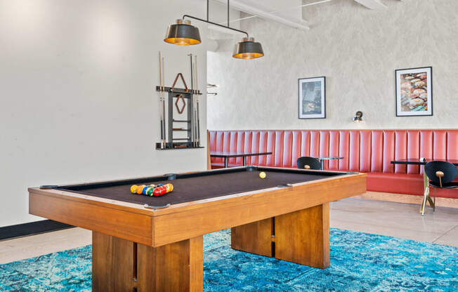 a pool table in a living room with a blue rug