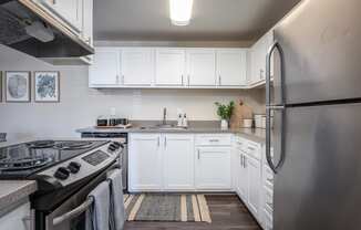 a kitchen with white cabinets and stainless steel appliances