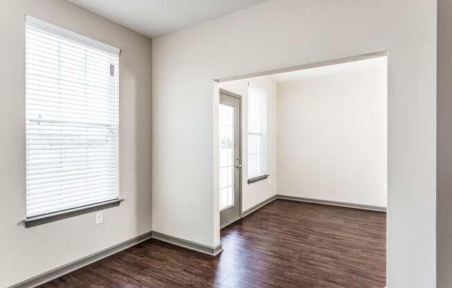 an empty living room with wood flooring and a window