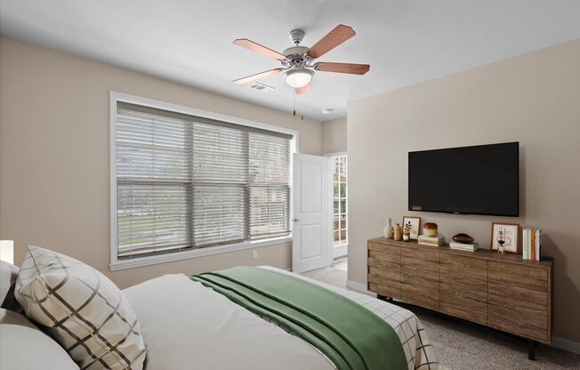 a bedroom with a large window and a ceiling fan