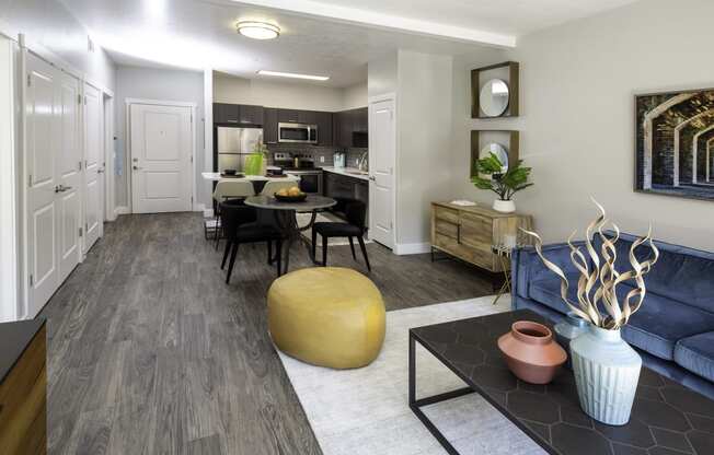 a living room with a couch and a table in front of a kitchen