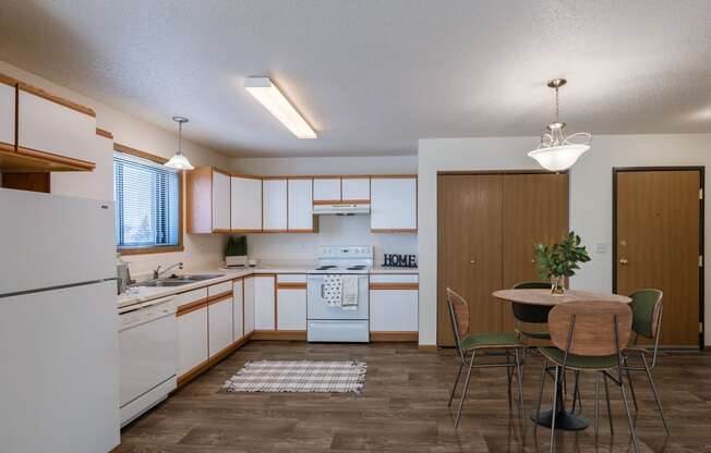 a kitchen and dining room with a table and chairs. Fargo, ND Eagle Run Apartments