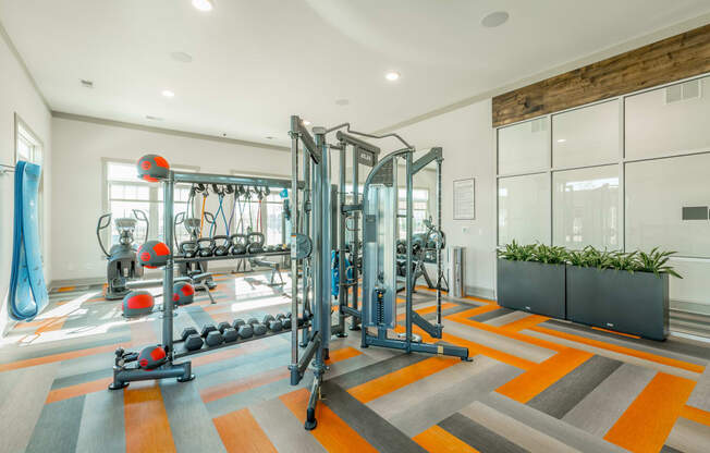 a workout room with a variety of exercise equipment and a large window