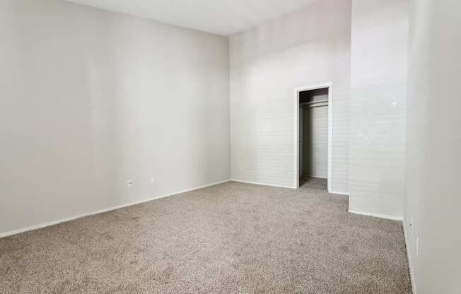 A room with a carpeted floor and a door on the right side.