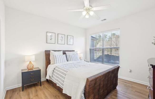 A bedroom with a large bed and a ceiling fan.