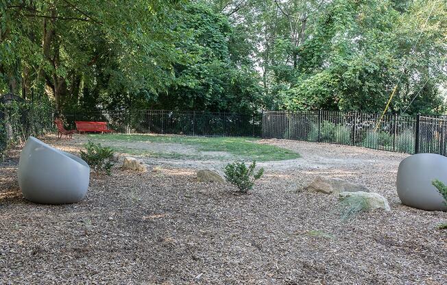 A garden with two large spherical objects and a red bench.