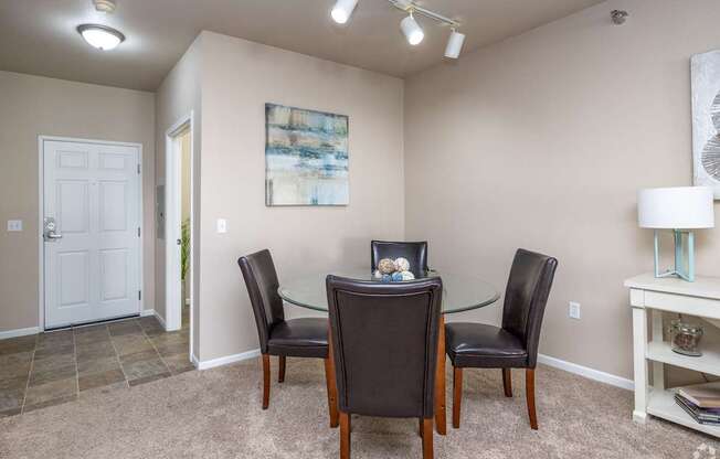 A dining room with a glass table and chairs.