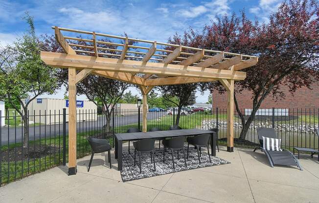 a pergola with a table and chairs under it