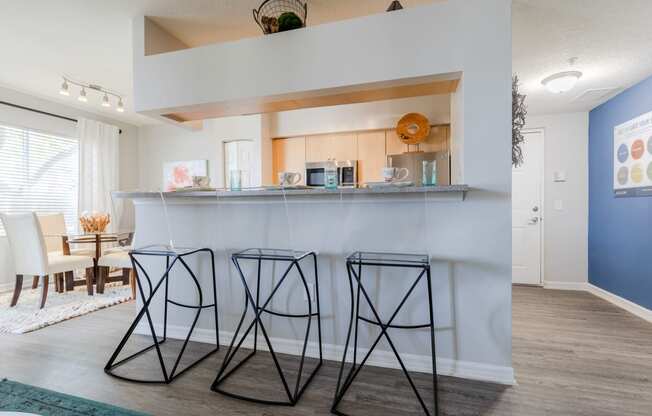 a kitchen with a bar and a dining room in the background at Heritage Bay, Jensen Beach, FL