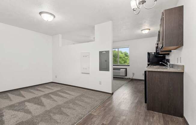 A spacious room with a patterned carpet and a wooden cabinet.