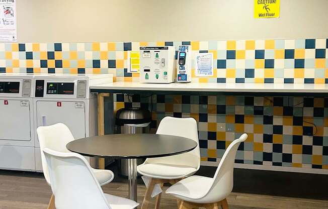 A kitchen with a table and chairs.