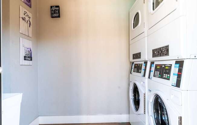 A row of white front load washing machines in a laundry facility at Mandarin Bay Apartments