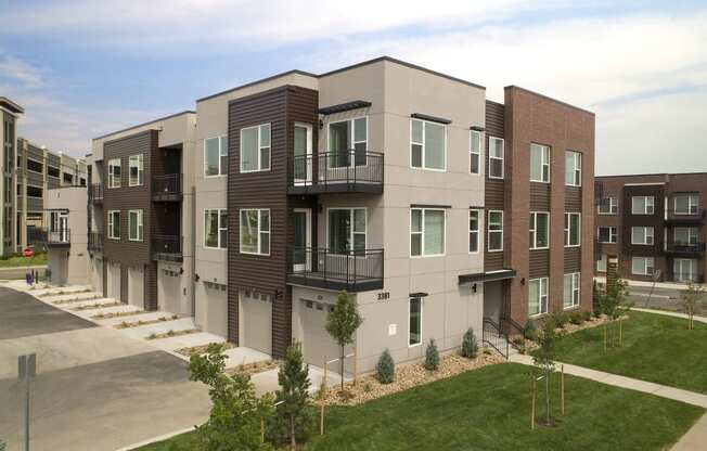 a rendering of a new apartment building with balconies and green grass