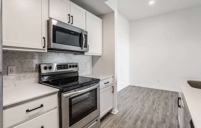 A kitchen with a stove top oven and microwave above it.