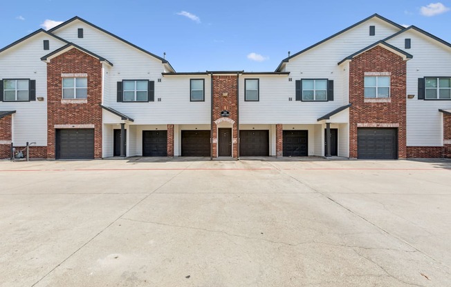A large, modern building with a white and brick facade and multiple garage doors.