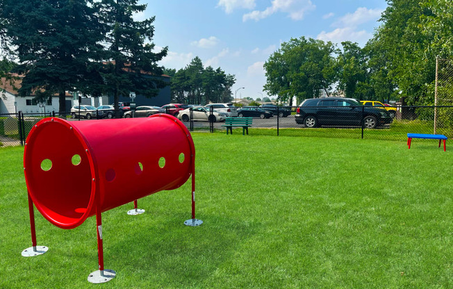 a red mailbox on a grassy field