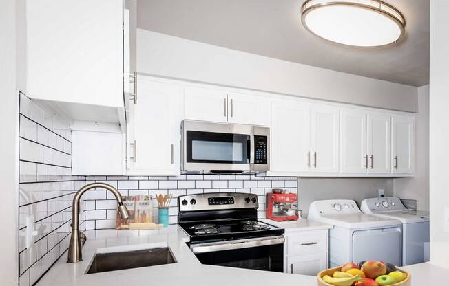 a kitchen with white cabinets and a sink and a microwave