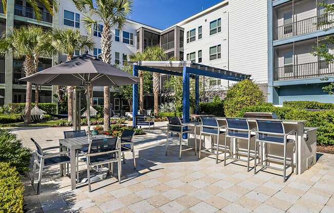 a patio with tables and chairs and umbrellas at an apartment building