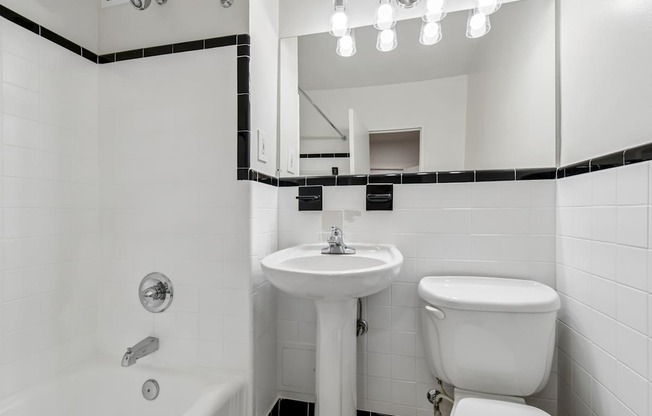 A white bathroom with a sink, toilet, and bathtub.