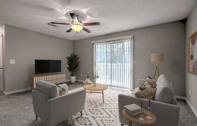 a living room with couches and a ceiling fan