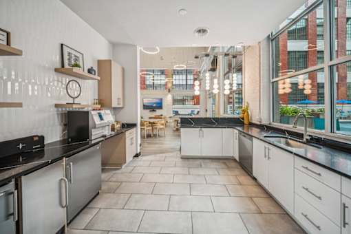 A modern kitchen with a black countertop and white cabinets.