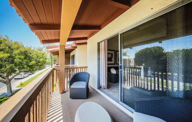 Sunny balcony with patio furniture and large sliding glass door